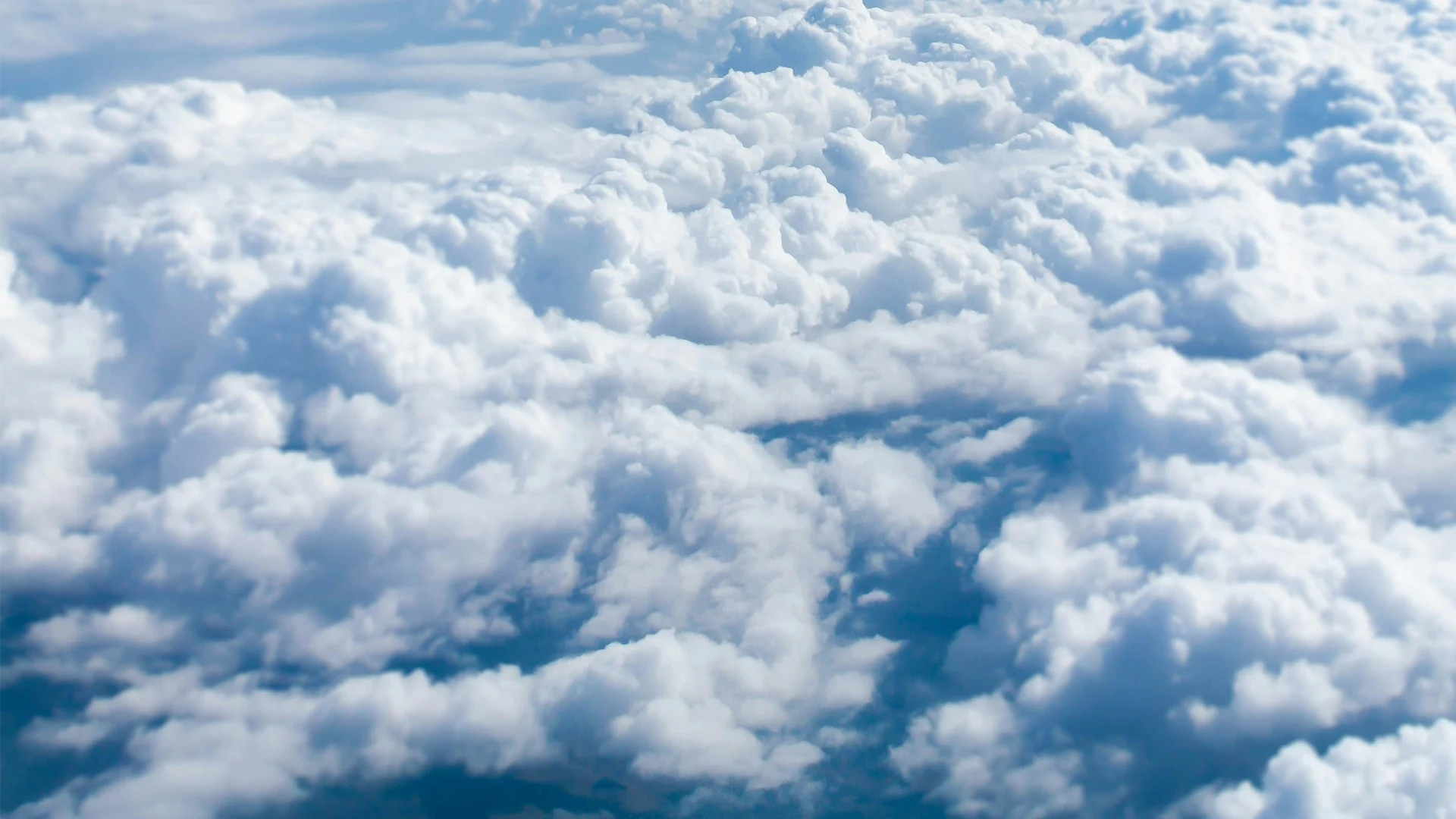 A photo of a sky filled with clouds where the photo is taken from an airplane.