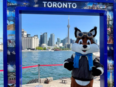 Une mascotte de l’aéroport pose dans un cadre photo Toronto au bord de l’eau.