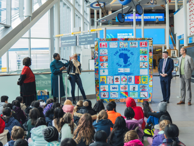 Des visiteurs assistent au dévoilement d’une installation textile dans l’atrium de l’aéroport.