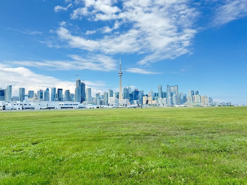 Un avion sur le terrain d’aviation, avec le panorama de Toronto à l’arrière-plan.