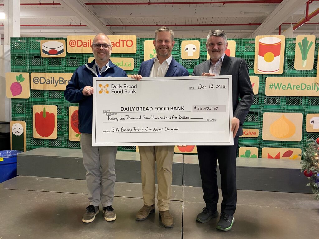 Des représentants de l’aéroport présentent un chèque à la banque alimentaire Daily Bread.