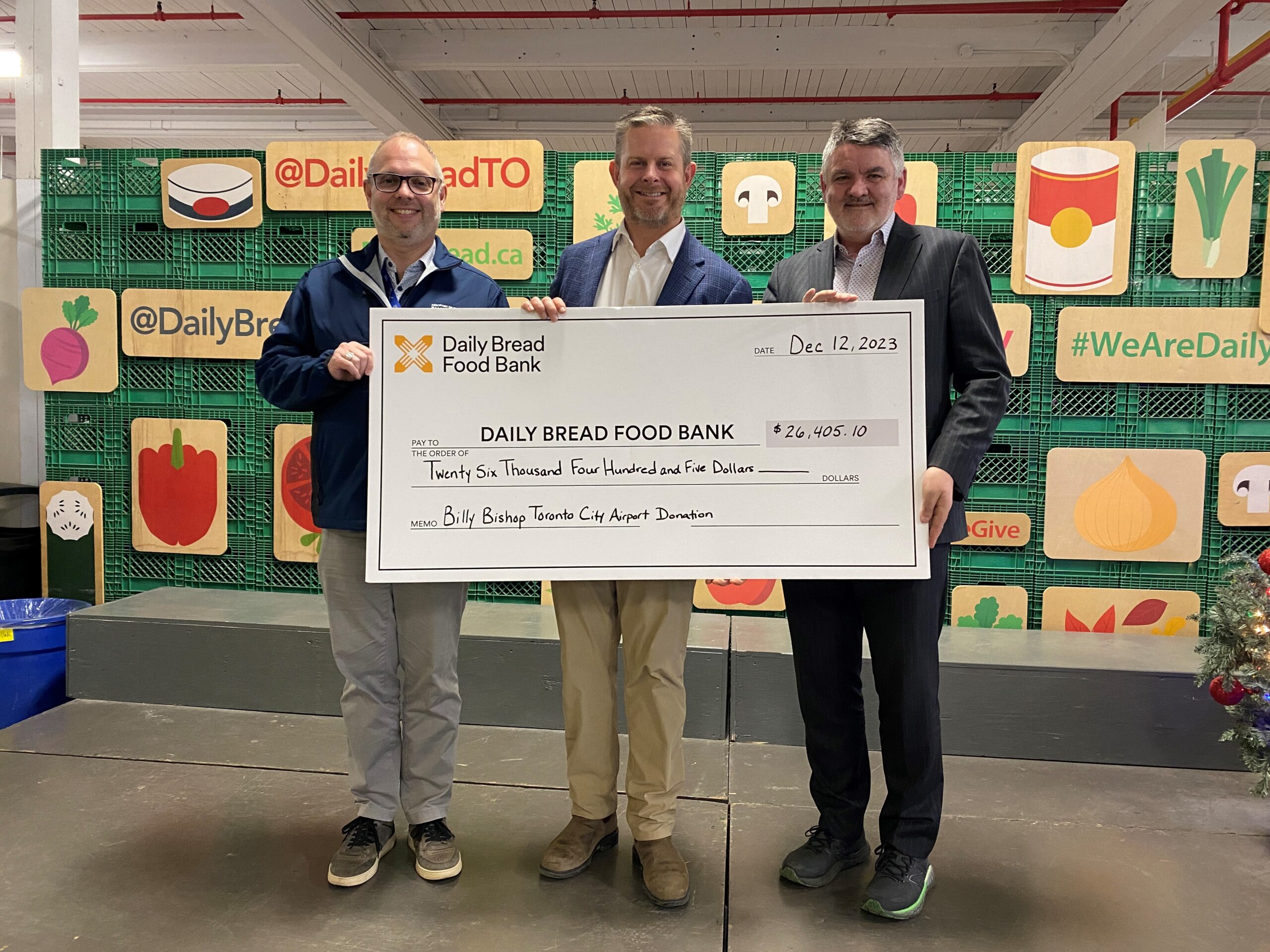 Des représentants de l’aéroport présentent un chèque à la banque alimentaire Daily Bread.