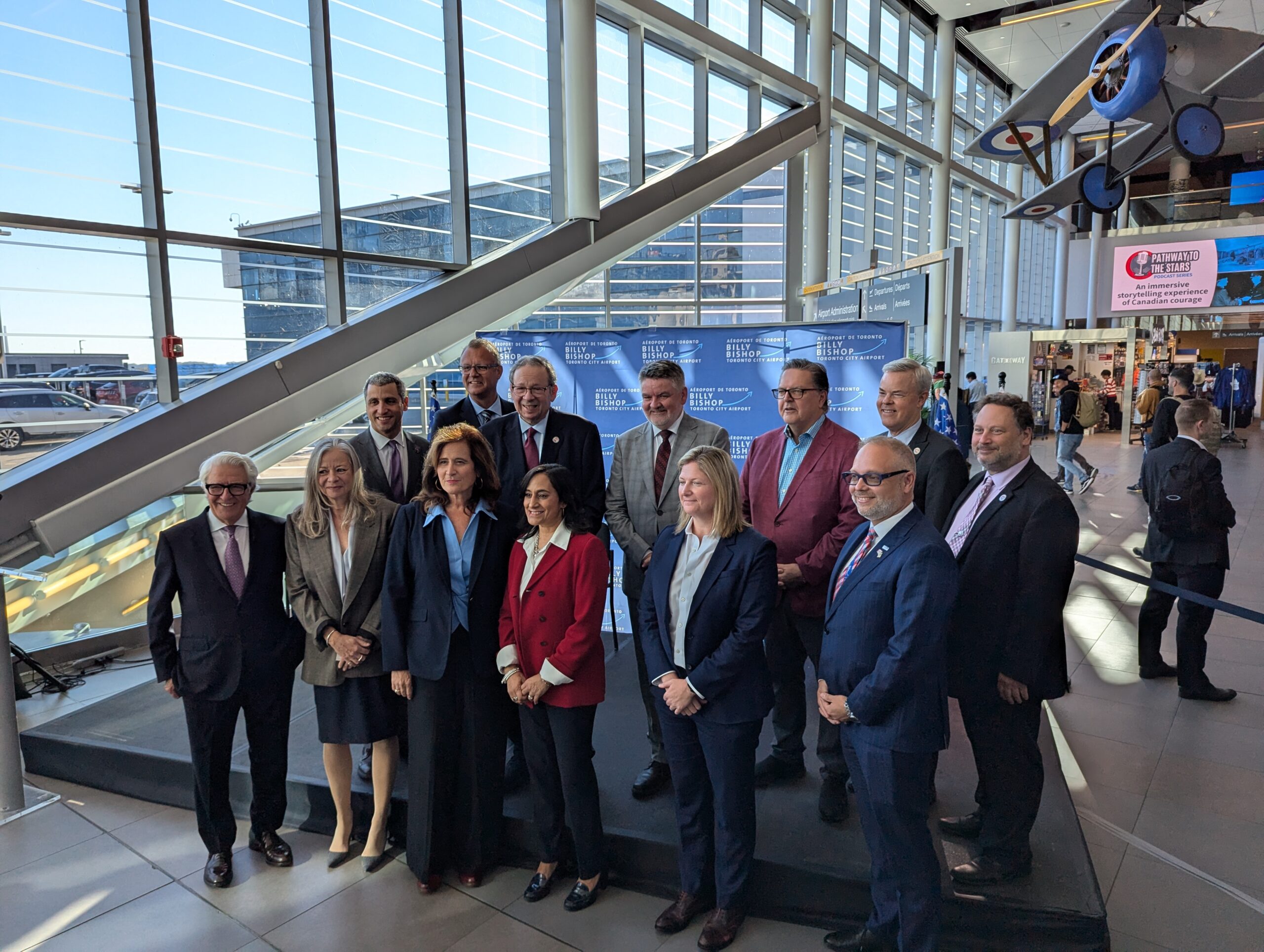 Des représentants se réunissent dans l’atrium de l’aéroport pour une annonce sur le précontrôle.