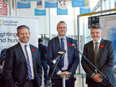 Des intervenants près d’un présentoir de la banque alimentaire Daily Bread dans l’atrium de l’aéroport.