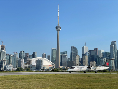Un avion sur le terrain d’aviation, avec le panorama de Toronto à l’arrière-plan.