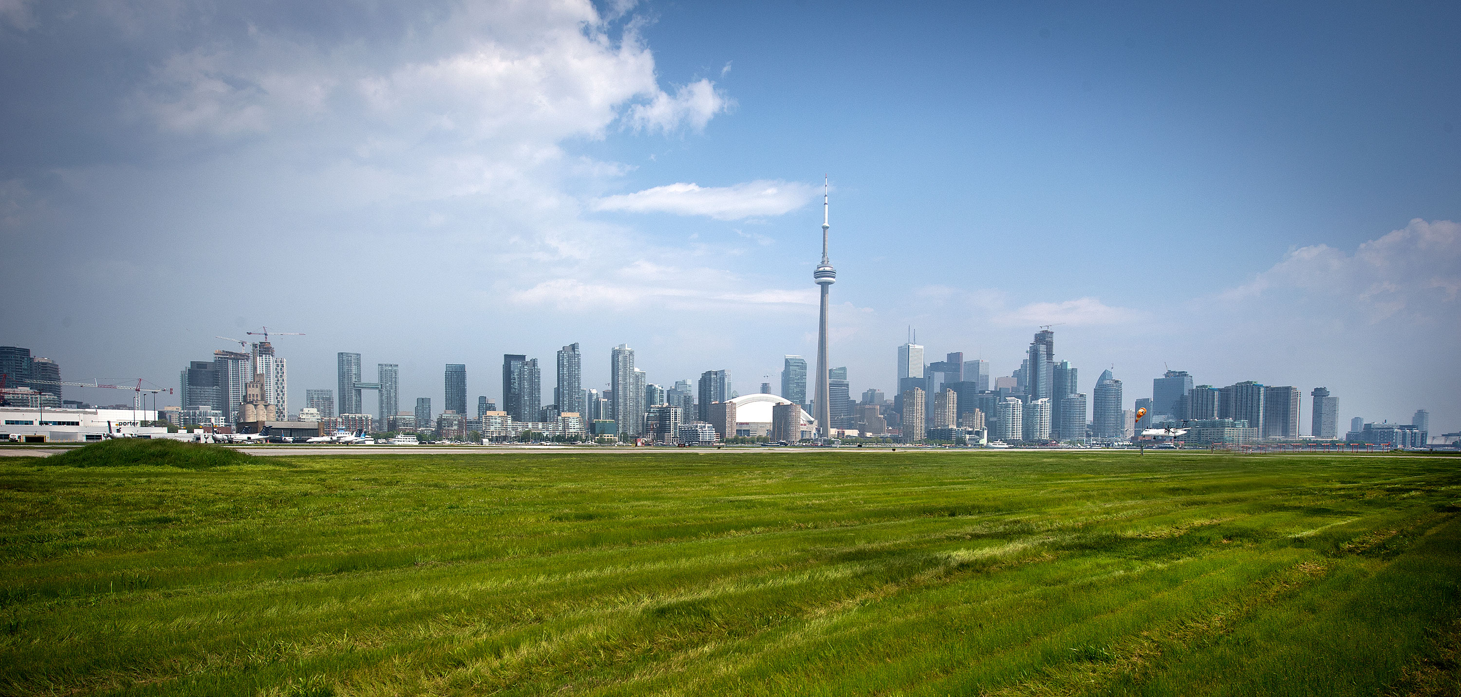 Un avion sur le terrain d’aviation, avec le panorama de Toronto à l’arrière-plan.